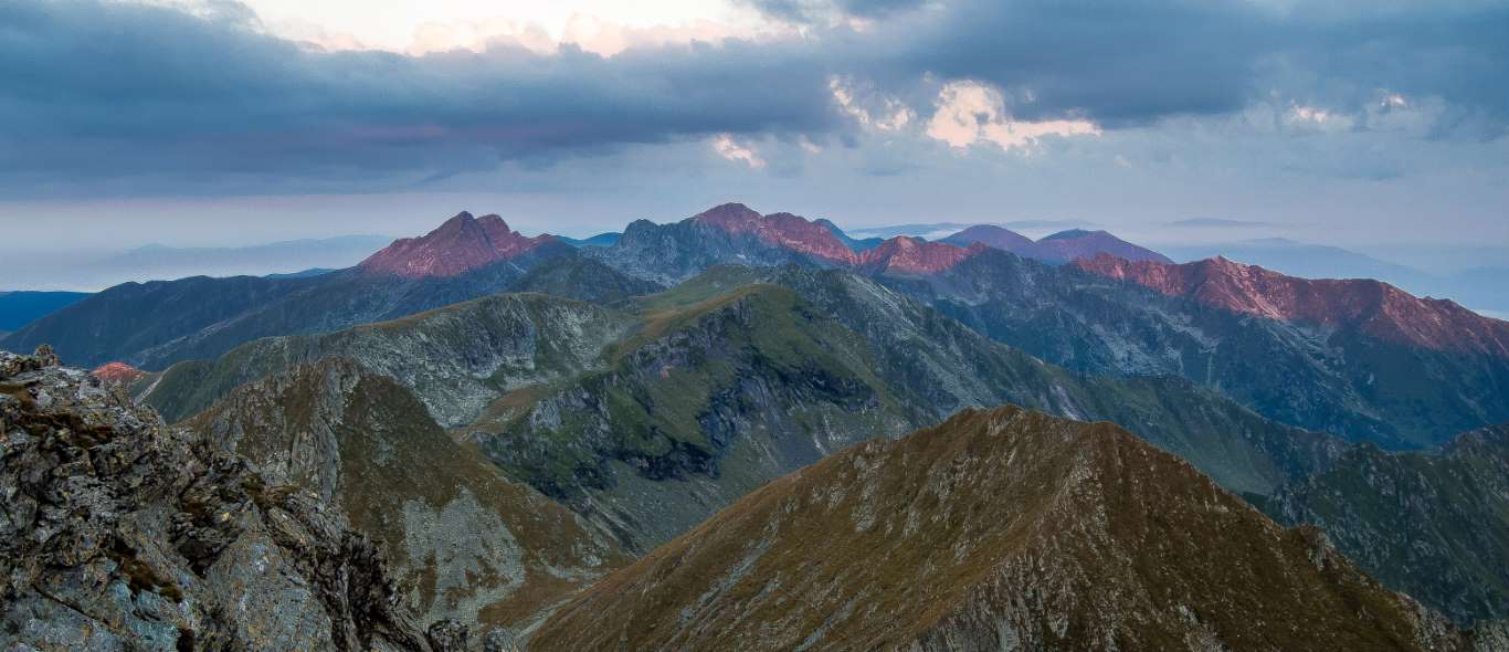 Culmile munților Făgăraș atinse blând de razele soarelui într-o dimineață limpede. Vedere de pe vârful Vânătarea lui Buteanu